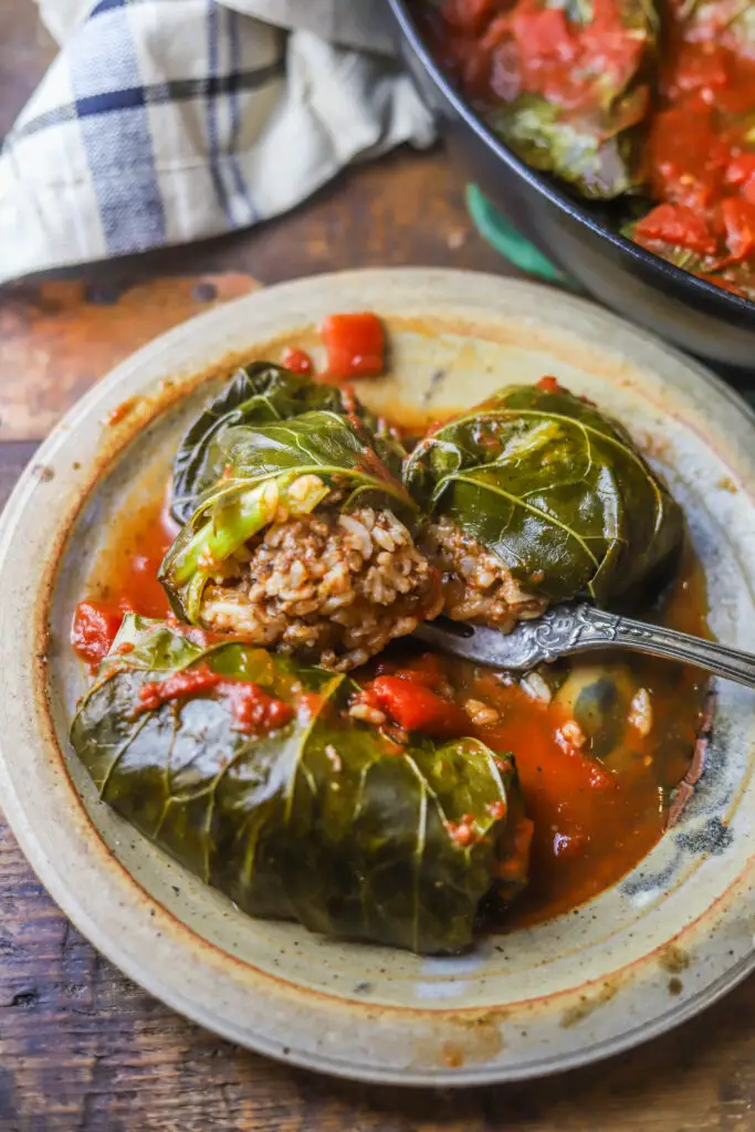 These stuffed collard greens. Just like stuffed cabbage rolls. These are big collard green leaves stuffed with a ground beef, rice and tomato sauce filling. These are so hearty and just a good one pot meal. If you like recipes with collard greens, this is it. 