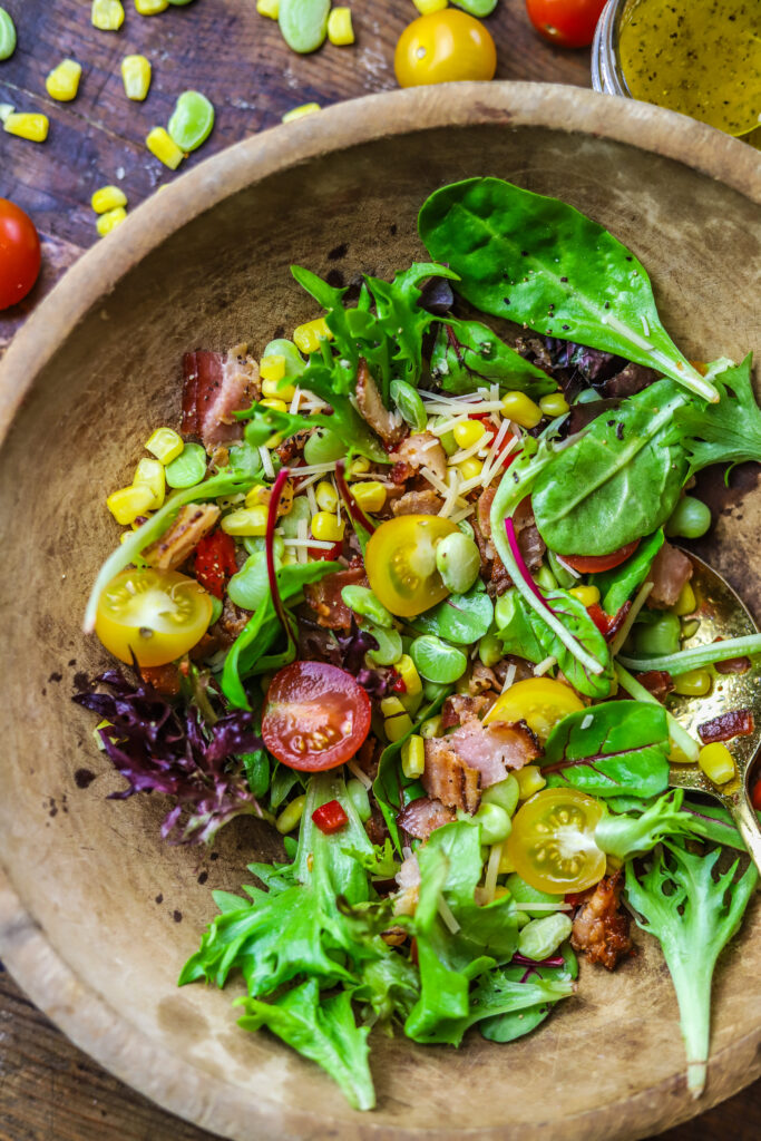 This corn succotash salad is perfect for a meal or for a side. It's packed with fresh greens, corn, baby lima beans, pimentos and bacon. Top it with a homemade sweet onion dressing to finish. This salad just screams Southern comfort thrown into a fresh and light salad.