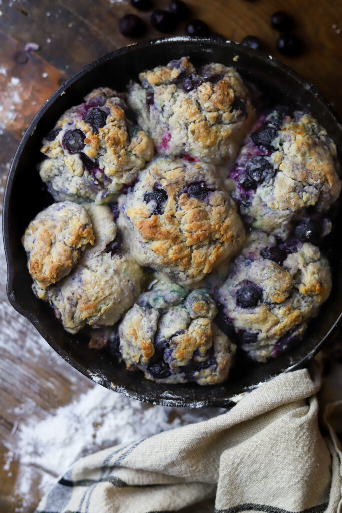 These country blueberry biscuits are literally so delicious and easy to make. I feel like these are really the old-fashioned way to make cathead biscuits. Instead of butter, you'll use shortening then mix together your flour, baking soda, sugar, and of course buttermilk. Knead them all together with some frozen blueberries into balls and bake them in a skillet with some melted butter for about 20 minutes until golden brown. These are the perfect breakfast or perfect for even just a snack. 