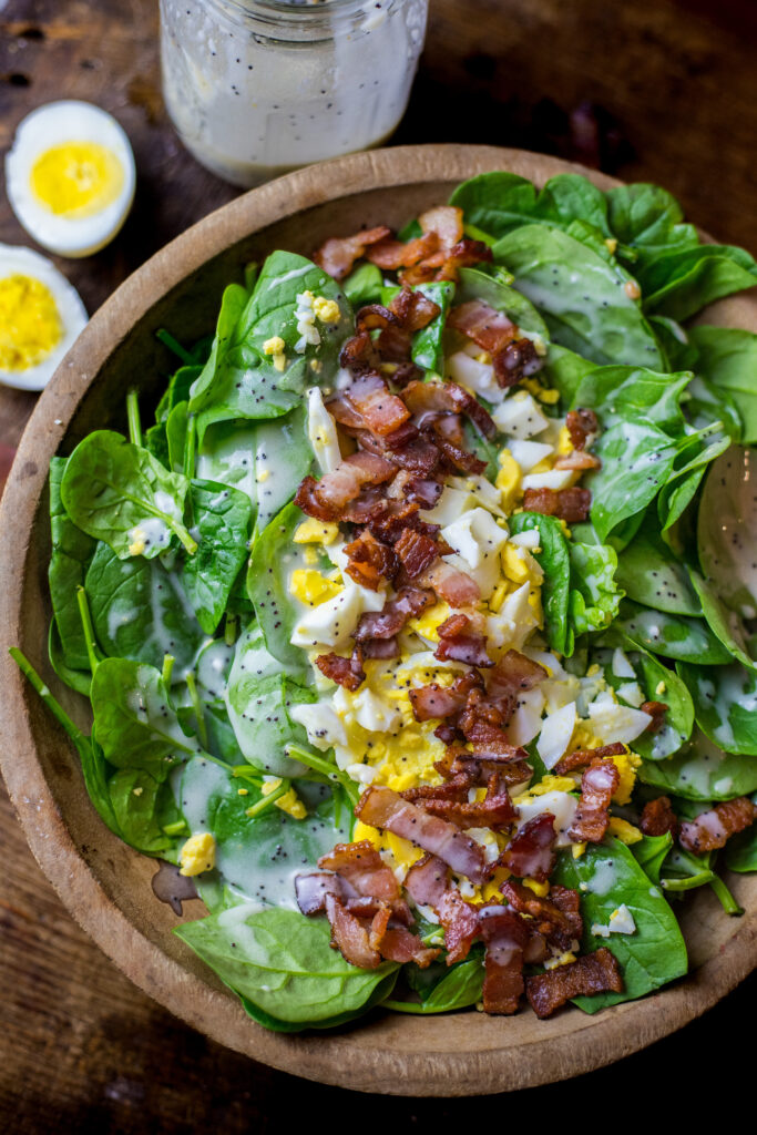 This spinach salad with bacon and eggs is a perfect blend of savory and sweet. The flavors of the salty bacon pair so well with the boiled egg and creamy poppyseed dressing. The dressing is so sweet and flavorful and super easy to make. You can't beat throwing together a salad with essentially 4 ingredients that's packed with flavor.