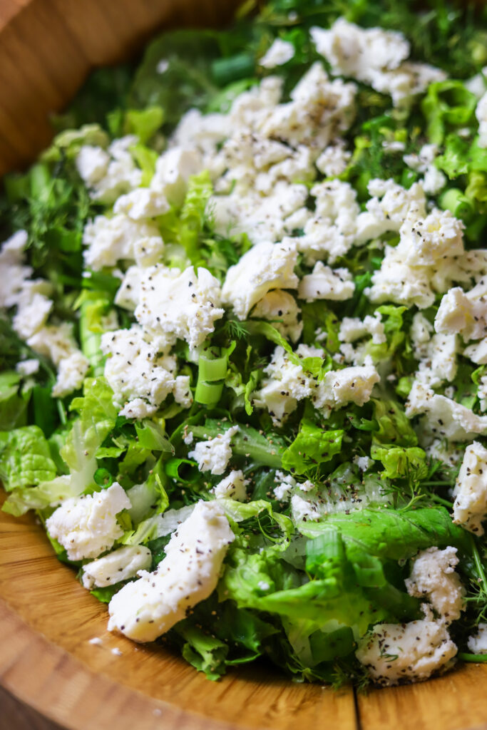 I love this simple dill salad. This salad is so light and fresh goes perfectly with anything. It's romaine lettuce sliced thinly with lots of green onions, fresh dill, feta cheese, top it off with some lemon, vinegar and olive oil dressing. That’s literally it. It takes less than five minutes to put together for the tastiest romaine salad. 