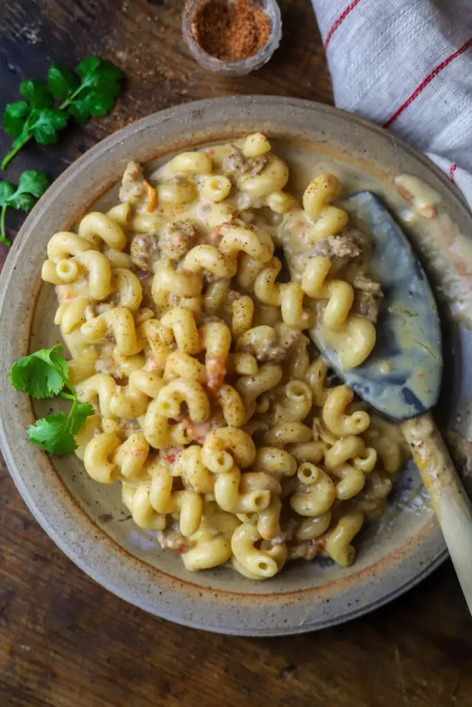 Loaded queso mac and cheese. It's a traditional queso recipe packed with Velveeta cheese, ground sausage, and Rotel tomatoes with some pasta folded in. Ok. I know it looks like hamburger helper but it's way more than that!! If you love queso dip, you'll love it with mac and cheese folded into it, I promise.