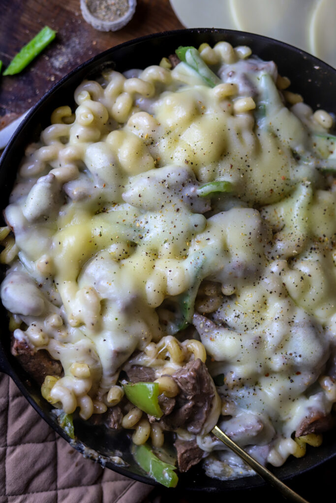 This philly cheesesteak pasta skillet is a perfect simple weeknight meal. Its bits of beef sauteed with bell peppers and onion then folded in with pasta and a cream of mushroom sauce. Then top it off with some provolone cheese and broil it until its nice and melted and bubbly. This one pot meal is perfect to make for a quick dinner.