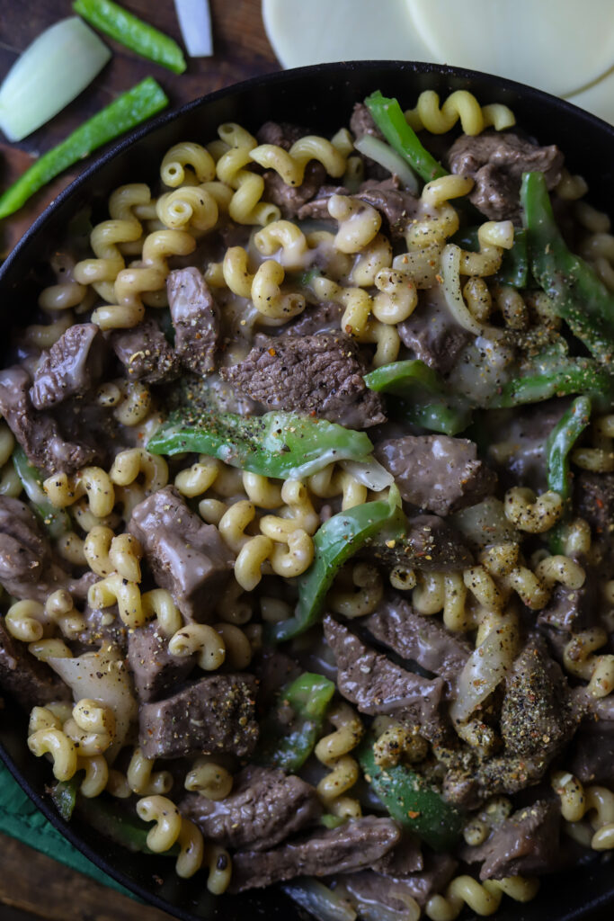 This philly cheesesteak pasta skillet is a perfect simple weeknight meal. Its bits of beef sauteed with bell peppers and onion then folded in with pasta and a cream of mushroom sauce. Then top it off with some provolone cheese and broil it until its nice and melted and bubbly. This one pot meal is perfect to make for a quick dinner.