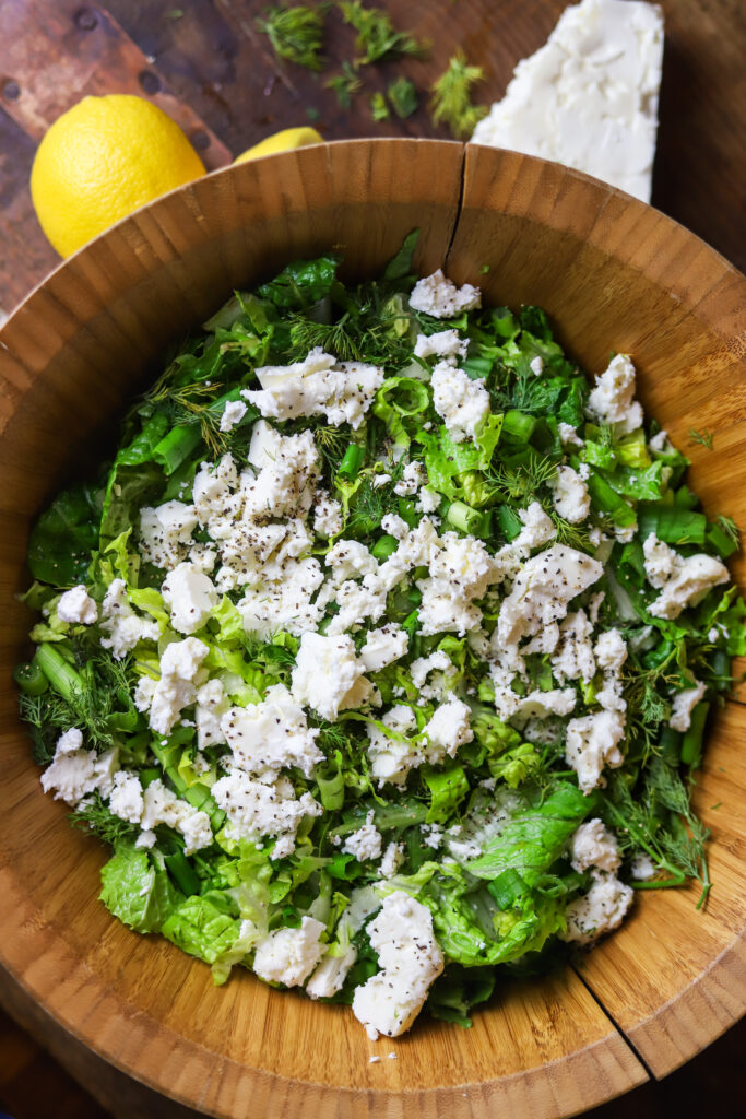 I love this simple dill salad. This salad is so light and fresh goes perfectly with anything. It's romaine lettuce sliced thinly with lots of green onions, fresh dill, feta cheese, top it off with some lemon, vinegar and olive oil dressing. That’s literally it. It takes less than five minutes to put together for the tastiest romaine salad. 