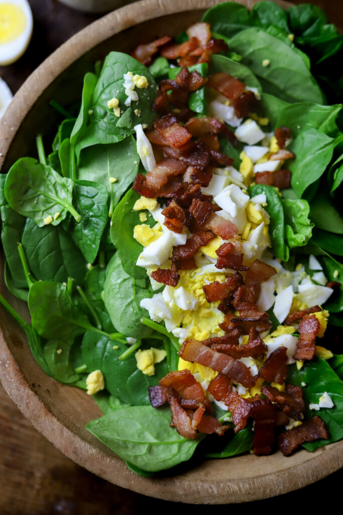 This spinach salad with bacon and eggs is a perfect blend of savory and sweet. The flavors of the salty bacon pair so well with the boiled egg and creamy poppyseed dressing. The dressing is so sweet and flavorful and super easy to make. You can't beat throwing together a salad with essentially 4 ingredients that's packed with flavor.