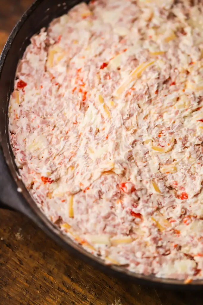 This baked summer sausage cheese dip. Mhmm. Perfect cheesy skillet appetizer. Kind of the same concept of a dried beef dip or appetizer, you'll take a summer sausage roll, chop it or grate it up, mix with some cheddar, cream cheese, pimentos and spices. Bake and serve. This is the most savory dip that is so good and perfect for any occasion.