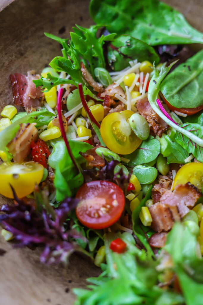 This corn succotash salad is perfect for a meal or for a side. It's packed with fresh greens, corn, baby lima beans, pimentos and bacon. Top it with a homemade sweet onion dressing to finish. This salad just screams Southern comfort thrown into a fresh and light salad.