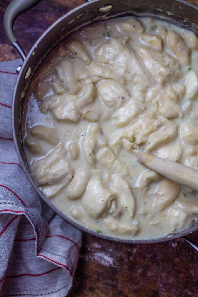 These chicken and dumplings with biscuits is seriously the best chicken and dumplings recipe ever. Hands down. You'll start with a broth base with some chicken, onions and celery. Drop in some cut up canned biscuits. Then, add in some milk, heavy cream, and...white country gravy mix. Yes, it's literally the last southern chicken and dumplings recipe you'll ever want or need and it's so simple to make.