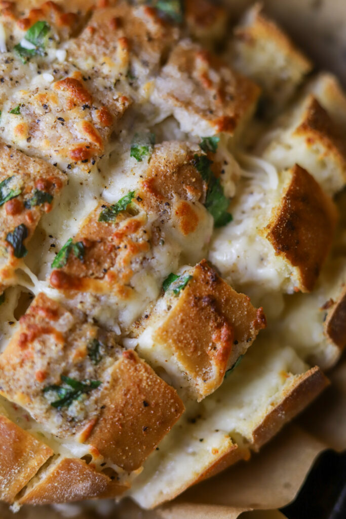 My family is so in love with this pepper jack cheesy pull apart bread. This is seriously the easiest bread appetizer there is. You’ll buy a round Italian loaf of bread, cut it crossways but not all the way through, stuff it with a whole bag of pepper jack cheese top it with some melted butter and spices. Bake for about 15 minutes and there you have it. This cheese bread appetizer is great for parties or even just to eat at home.