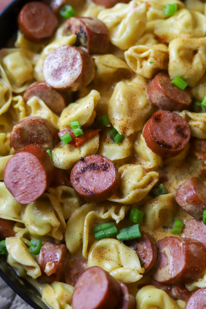 This Cajun sausage and cheese tortellini skillet is the perfect quick dinner. All you’re gonna do is boil some cheese tortellini and brown some smoked sausage. Remove it from the skillet and whisk up a cheesy spicy Cajun sauce. Toss them all back into the same skillet if you have the perfect one pot meal. 