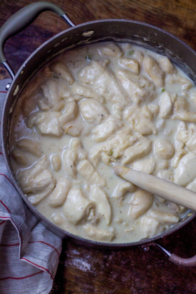 These chicken and dumplings with biscuits is seriously the best chicken and dumplings recipe ever. Hands down. You'll start with a broth base with some chicken, onions and celery. Drop in some cut up canned biscuits. Then, add in some milk, heavy cream, and...white country gravy mix. Yes, it's literally the last southern chicken and dumplings recipe you'll ever want or need and it's so simple to make.