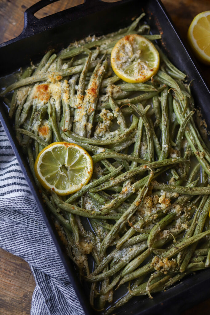 These lemon parmesan green beans are the best side vegetable. They are fresh green beans topped with garlic, butter, lemon, and grated parmesan cheese. Just dump them all in a dish and bake for about 20-25 minutes. So simple and the best side dish. 