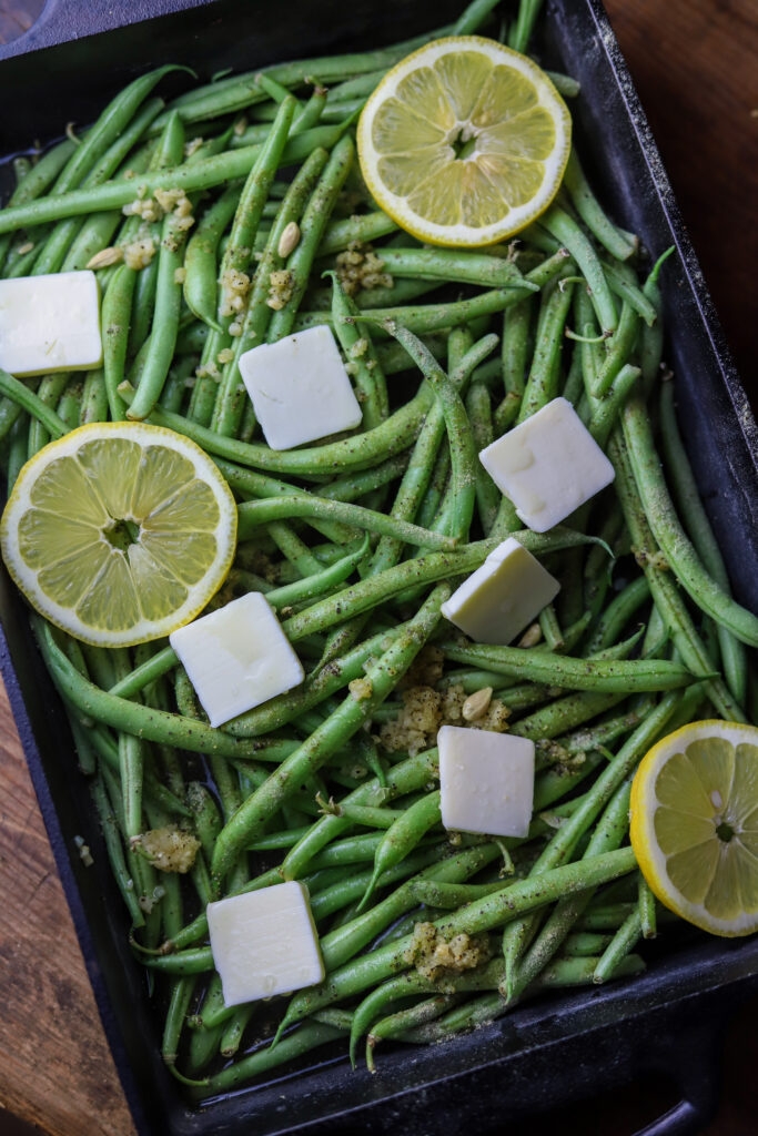 These lemon parmesan green beans are the best side vegetable. They are fresh green beans topped with garlic, butter, lemon, and grated parmesan cheese. Just dump them all in a dish and bake for about 20-25 minutes. So simple and the best side dish. 