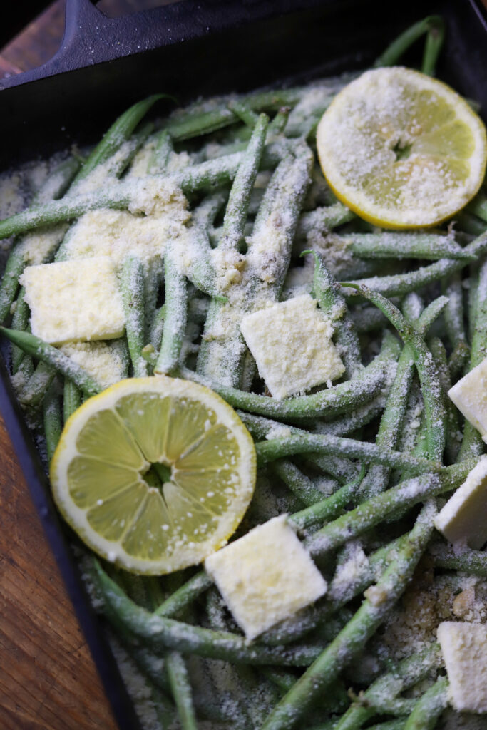 These lemon parmesan green beans are the best side vegetable. They are fresh green beans topped with garlic, butter, lemon, and grated parmesan cheese. Just dump them all in a dish and bake for about 20-25 minutes. So simple and the best side dish. 