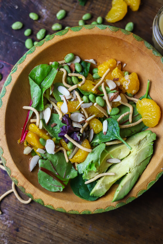 This mandarin orange, green Asian salad is such an easy salad to throw together. It's a sweet salad of a mix of greens with mandarin oranges, avocado, edamame, almonds and chow mein noodles. I topped it with a storebought champagne salad dressing, and it was perfect. This Asian salad recipe is the perfect mix of sweet and savory and soft and crunchy. Make it a meal or just serve it as a side.