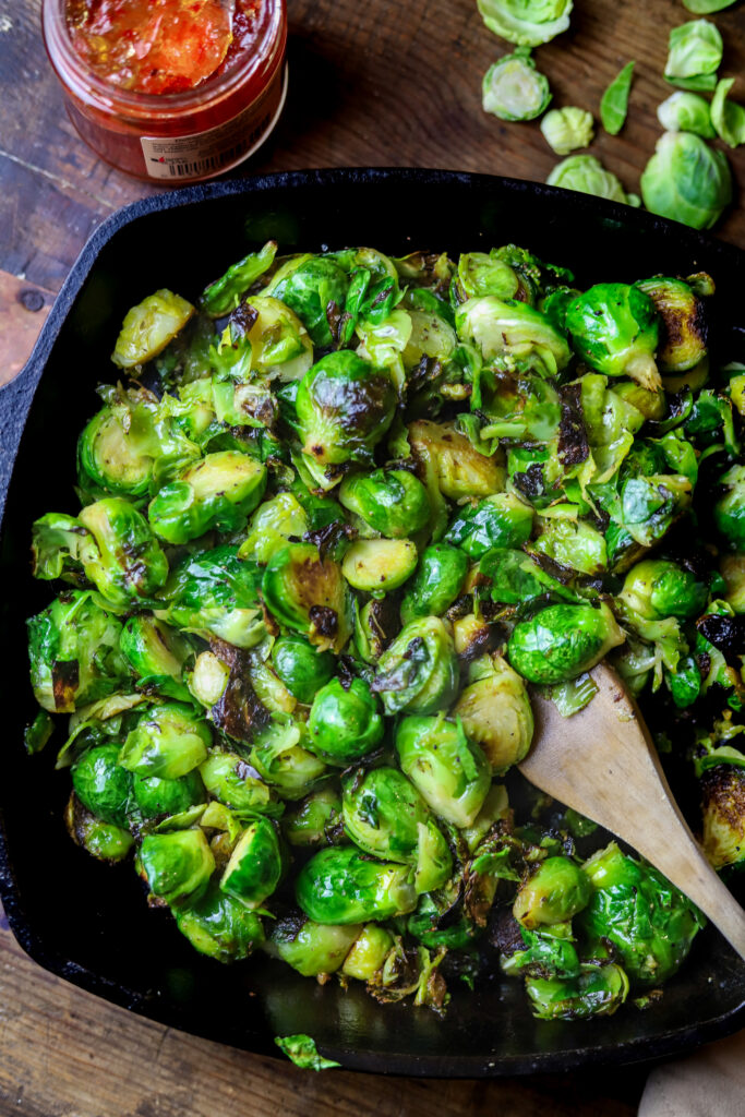 These pepper jelly caramelized brussel sprouts have become a favorite around here. They only require two ingredients along with some salt and pepper and that's it. You'll sauté the brussel sprouts in cast iron, then remove from heat and stir in some spicy pepper jelly. Taking less than 10 minutes to make, you seriously can't beat them. Plus, they are amazingly delicious.