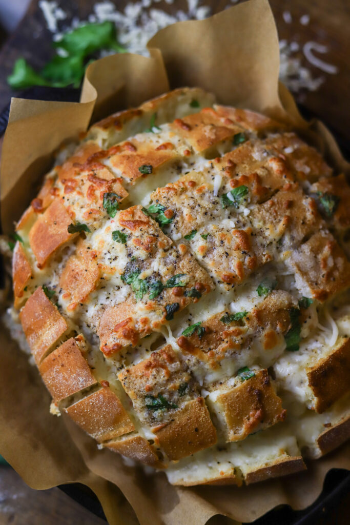 My family is so in love with this pepper jack cheesy pull apart bread. This is seriously the easiest bread appetizer there is. You’ll buy a round Italian loaf of bread, cut it crossways but not all the way through, stuff it with a whole bag of pepper jack cheese top it with some melted butter and spices. Bake for about 15 minutes and there you have it. This cheese bread appetizer is great for parties or even just to eat at home.