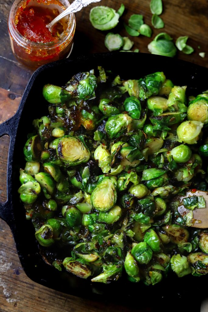 These pepper jelly caramelized brussel sprouts have become a favorite around here. They only require two ingredients along with some salt and pepper and that's it. You'll sauté the brussel sprouts in cast iron, then remove from heat and stir in some spicy pepper jelly. Taking less than 10 minutes to make, you seriously can't beat them. Plus, they are amazingly delicious.