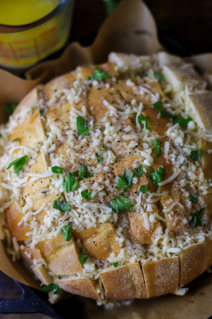 My family is so in love with this pepper jack cheesy pull apart bread. This is seriously the easiest bread appetizer there is. You’ll buy a round Italian loaf of bread, cut it crossways but not all the way through, stuff it with a whole bag of pepper jack cheese top it with some melted butter and spices. Bake for about 15 minutes and there you have it. This cheese bread appetizer is great for parties or even just to eat at home.