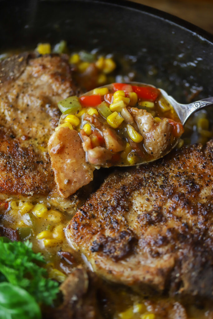 This one pot pork chop maque choux. Maque choux is a traditional, southern corn dish with peppers and ham or bacon. This one pot recipe combines it all with a pan fried, bone-in pork chop, on top a of corn, bell pepper, and bacon mixture. Add a cream of celery to give it a gravy feel then serve it all over rice or mashed potatoes. This recipe is so simple and perfect for dinner. 