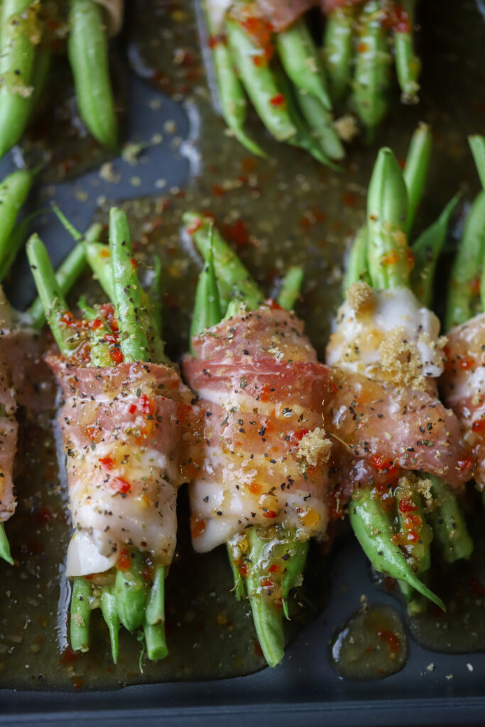 Ok y'all. These zesty Italian bacon wrapped green beans. Simplest, easiest and most delicious side veggie. You'll take some fresh green beans, make a little bundle, wrap them in bacon, then top with a few seasonings, brown sugar, and zesty Italian salad dressing. Bake and that's it. So simple and so delicious!