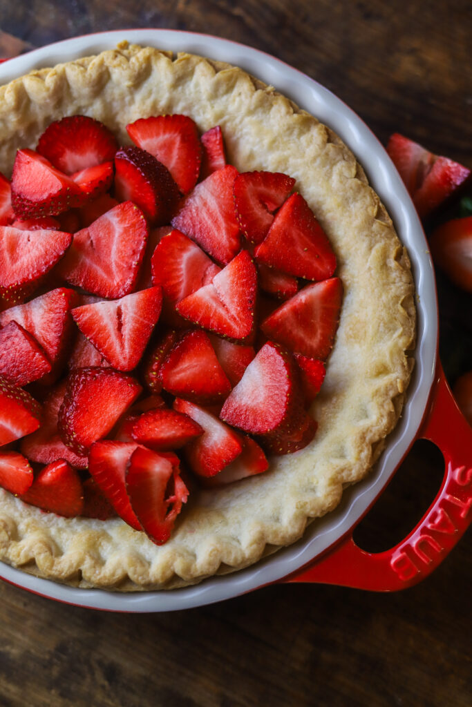 I love an old-fashioned strawberry pie. So this recipe has a twist on the Marie Callender's fresh strawberry pie. I had a pie crust and some fresh strawberries and decided to throw it all together. Once thing I do like about this recipe, is the strawberry part is not too sweet. If that's even possible? It pairs perfect with the flaky crust, and my personal favorite part, a thick layer of homemade whipped cream topping. Top it more fresh strawberries to finish it off. This pie just looks delicious. Read along to see how I made this simple strawberry pie in no time.