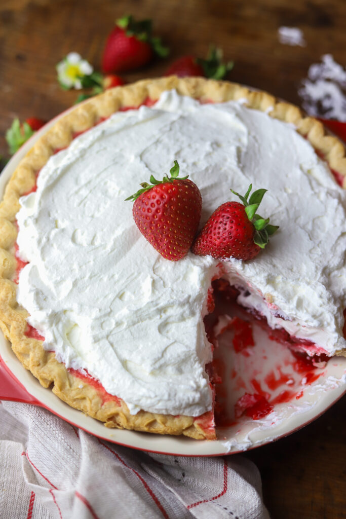 I love an old-fashioned strawberry pie. So this recipe has a twist on the Marie Callender's fresh strawberry pie. I had a pie crust and some fresh strawberries and decided to throw it all together. Once thing I do like about this recipe, is the strawberry part is not too sweet. If that's even possible? It pairs perfect with the flaky crust, and my personal favorite part, a thick layer of homemade whipped cream topping. Top it more fresh strawberries to finish it off. This pie just looks delicious. Read along to see how I made this simple strawberry pie in no time.