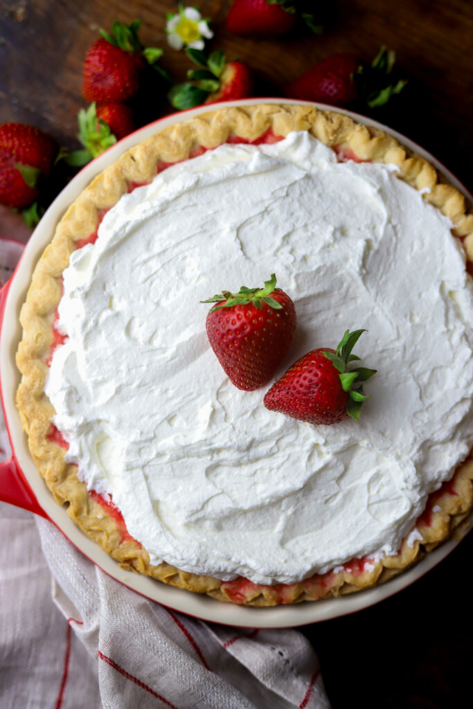 I love an old-fashioned strawberry pie. So this recipe has a twist on the Marie Callender's fresh strawberry pie. I had a pie crust and some fresh strawberries and decided to throw it all together. Once thing I do like about this recipe, is the strawberry part is not too sweet. If that's even possible? It pairs perfect with the flaky crust, and my personal favorite part, a thick layer of homemade whipped cream topping. Top it more fresh strawberries to finish it off. This pie just looks delicious. Read along to see how I made this simple strawberry pie in no time.