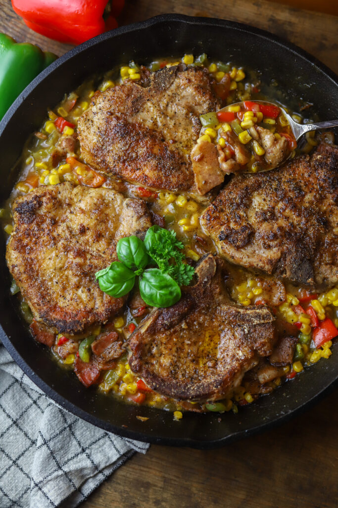 This one pot pork chop maque choux. Maque choux is a traditional, southern corn dish with peppers and ham or bacon. This one pot recipe combines it all with a pan fried, bone-in pork chop, on top a of corn, bell pepper, and bacon mixture. Add a cream of celery to give it a gravy feel then serve it all over rice or mashed potatoes. This recipe is so simple and perfect for dinner. 