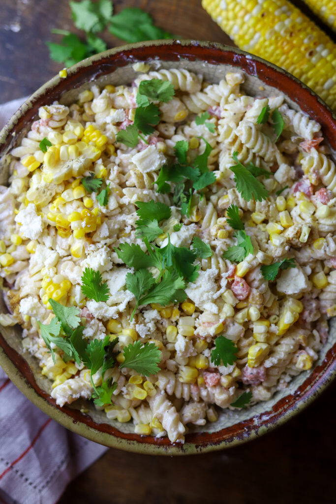 You'll love this Mexican street corn pasta salad. It's a mix of rotini pasta, two types of roasted corn, a can of Rotel tomatoes, Cotija cheese and a spicy dressing. This is such a fun, delicious and simple way to make pasta salad, and there are so many ways to serve it.