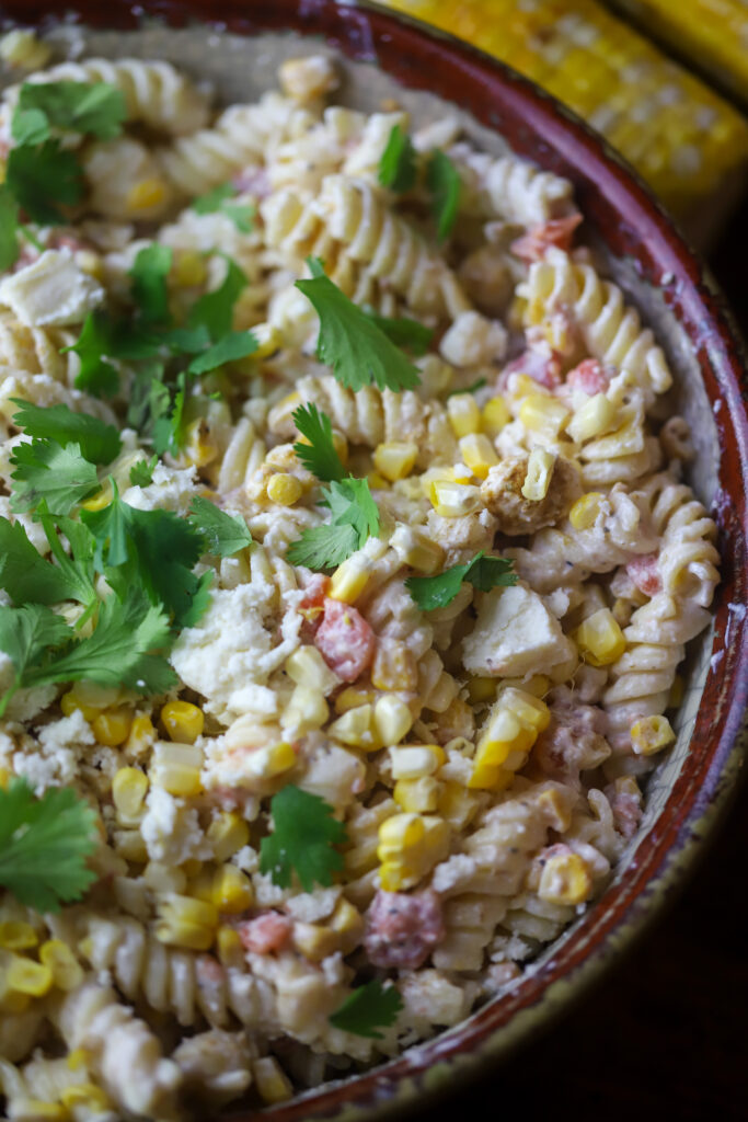 You'll love this Mexican street corn pasta salad. It's a mix of rotini pasta, two types of roasted corn, a can of Rotel tomatoes, Cotija cheese and a spicy dressing. This is such a fun, delicious and simple way to make pasta salad, and there are so many ways to serve it.