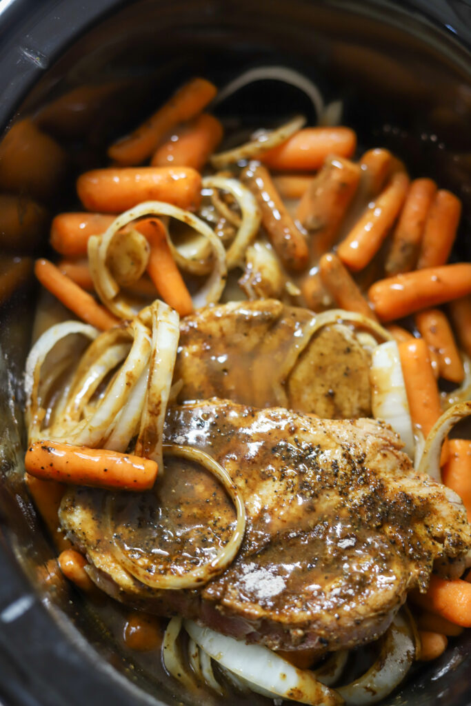 I love these bone-in smothered crockpot pork chops. These are such an easy and delicious comfort food. I started by searing my porkchops in a skillet then added them to my crockpot with some gravy mix, a can of gravy, and some beef consommé. Add some veggies like onions and carrots to complete it. This recipe tastes best over rice or mashed potatoes. You can't beat this comfort dish.