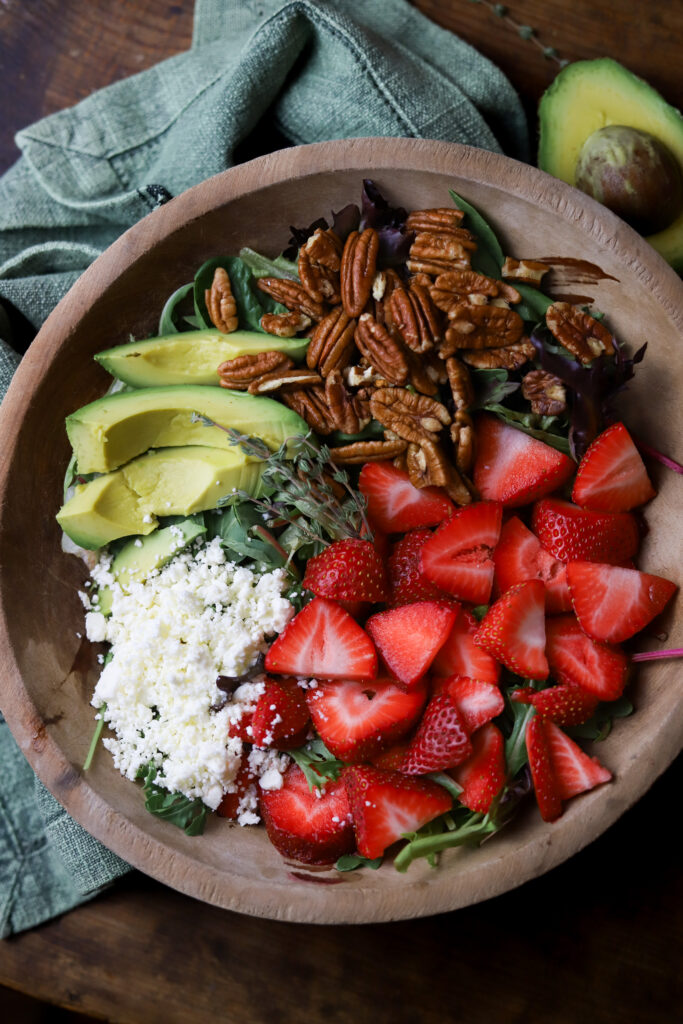 This strawberry pecan salad with pepper jelly vinaigrette is literally so good. You can also make this salad any time of year. All you’re going to need is a bed of greens, some strawberries, feta cheese, roasted pecans and then make this homemade vinaigrette made with pepper jelly. It’s so simple to make and delicious.