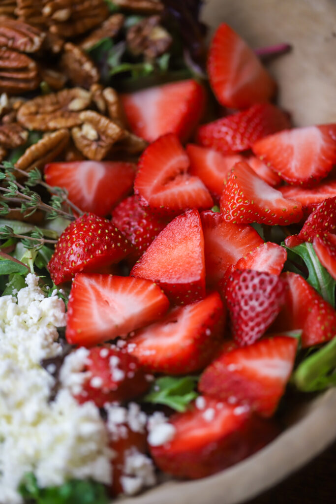 This strawberry pecan salad with pepper jelly vinaigrette is literally so good. You can also make this salad any time of year. All you’re going to need is a bed of greens, some strawberries, feta cheese, roasted pecans and then make this homemade vinaigrette made with pepper jelly. It’s so simple to make and delicious.