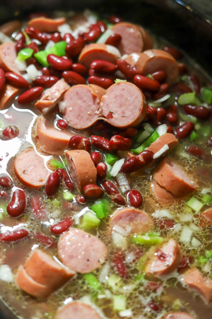 You'll love this easy crockpot red beans and rice. This is the easiest comfort food. You'll need some canned red kidney beans, smoked sausage, some Cajun holy trinity, and of a few seasonings. Let it slow cook all day on high. Serve it with white rice and that's it. This is perfect for a crowd or just as an easy dinner at home. 