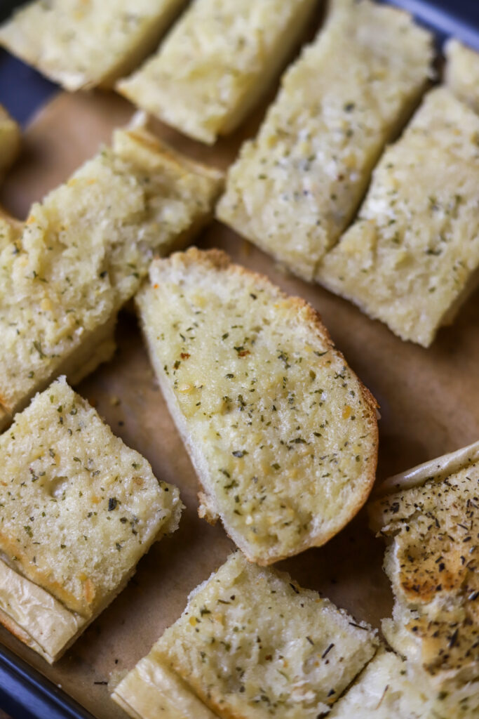 You've got to make this quick and easy garlic bread. It's the best two ingredient garlic bread. All you're going to need is an Italian loaf from the bakery of your grocery store and Land O Lakes garlic and herb spread. If you need a quick garlic bread for any meal, this is it. It's so delicious.