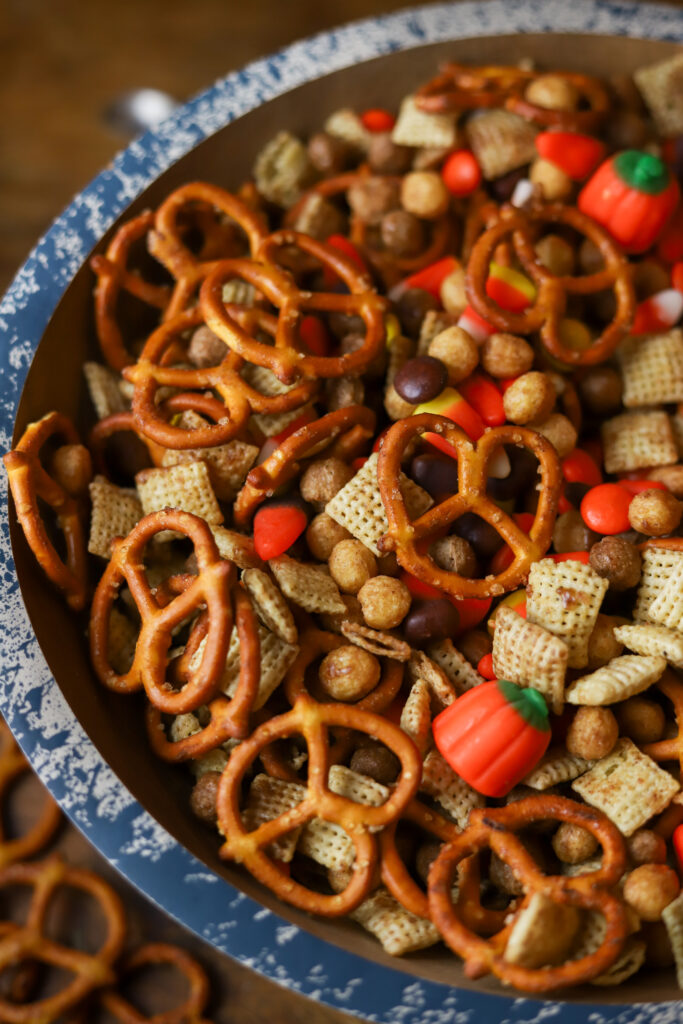 I am in love with this Halloween Chex mix recipe. It has the sweetness and the salty components with my personal favorite, candy corn! This mix is tossed and slow baked in a very generous amount of melted butter with brown sugar, cinnamon, and maple extract. I just want to tell you; this Halloween snack mix is addicting. I keep this on hand season, and it's so easy to make! You could even hand it out as little trick or treat goodie bags! 