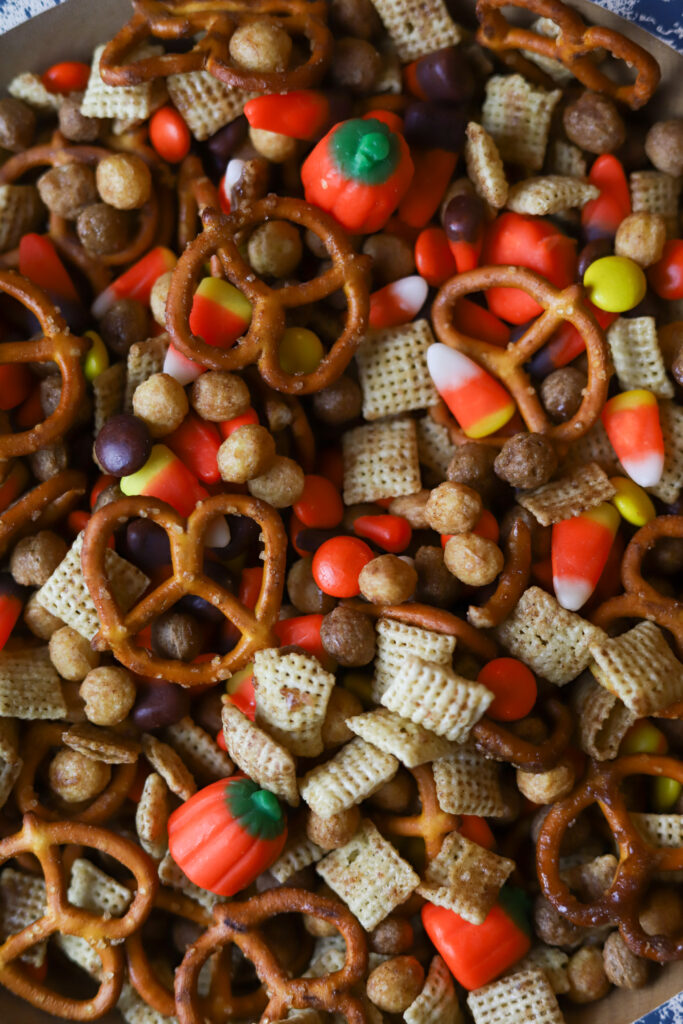 I am in love with this Halloween Chex mix recipe. It has the sweetness and the salty components with my personal favorite, candy corn! This mix is tossed and slow baked in a very generous amount of melted butter with brown sugar, cinnamon, and maple extract. I just want to tell you; this Halloween snack mix is addicting. I keep this on hand season, and it's so easy to make! You could even hand it out as little trick or treat goodie bags! 